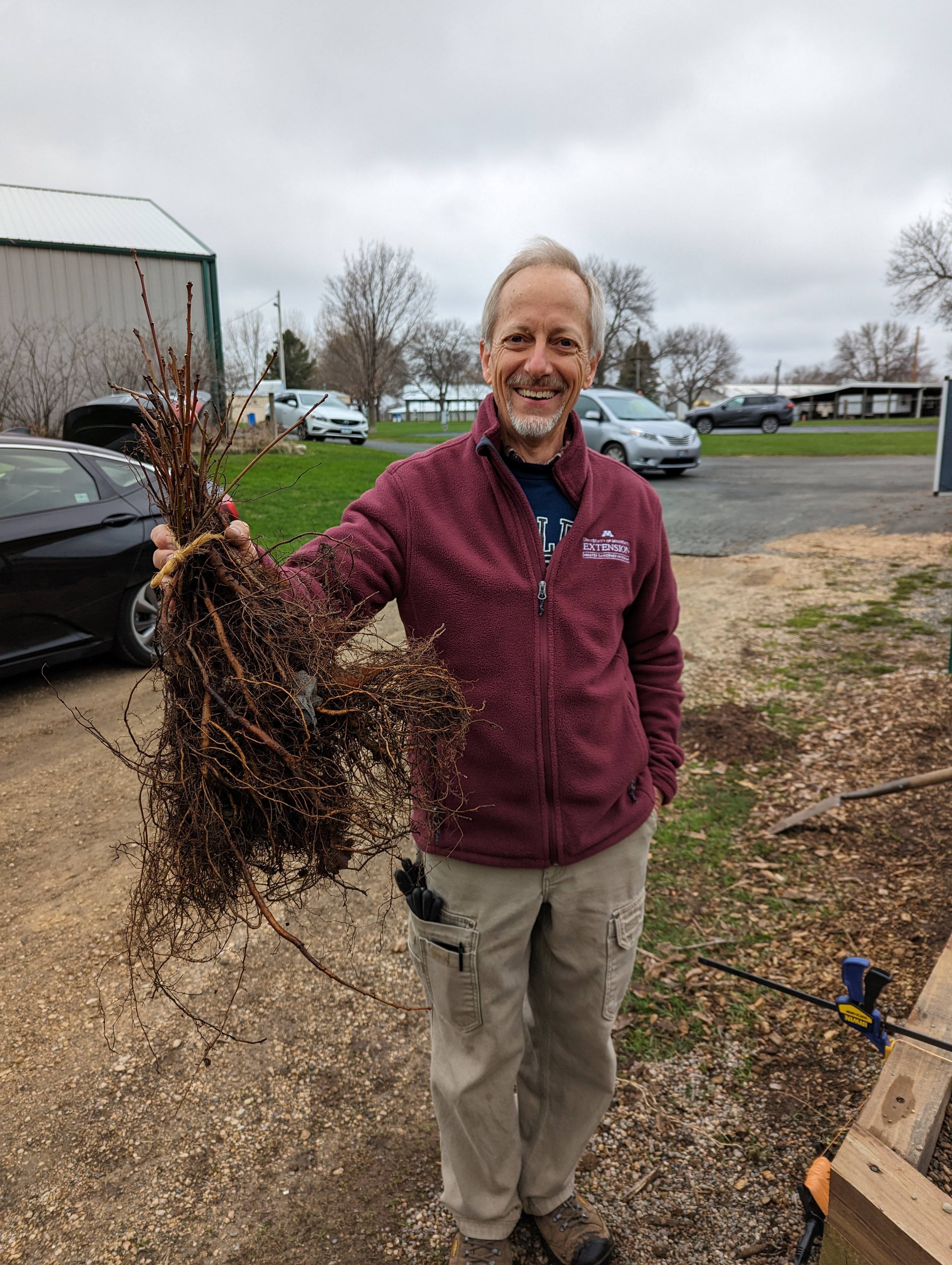 Master gardener volunteer Blair Johnson holds a group of seedlings