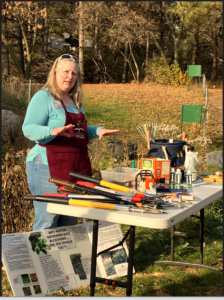 A volunteer educator is outdoors at a nature center to provide education about removing buckthorn
