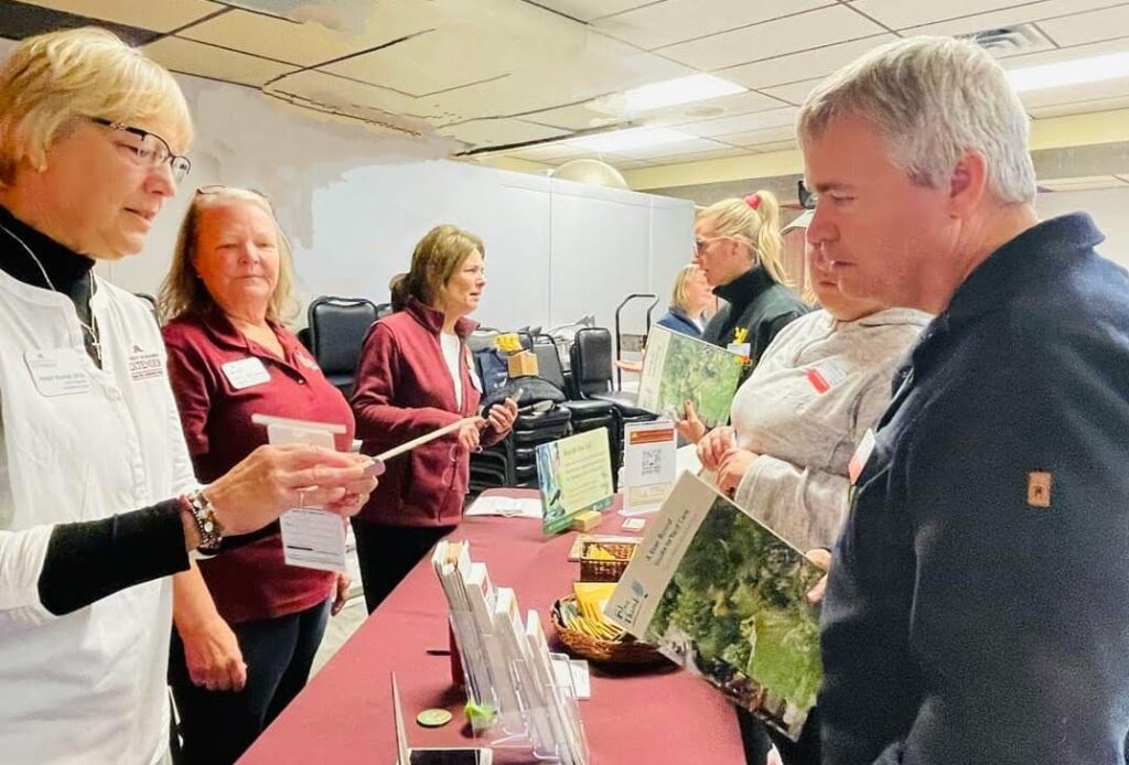 Volunteers talk with the public at an ask a master gardener booth